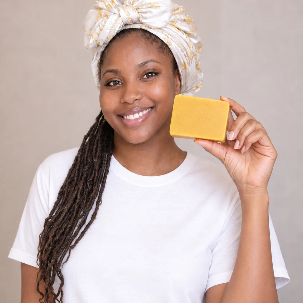 Femme présentant un savon au curcuma dans une ambiance de soin douce